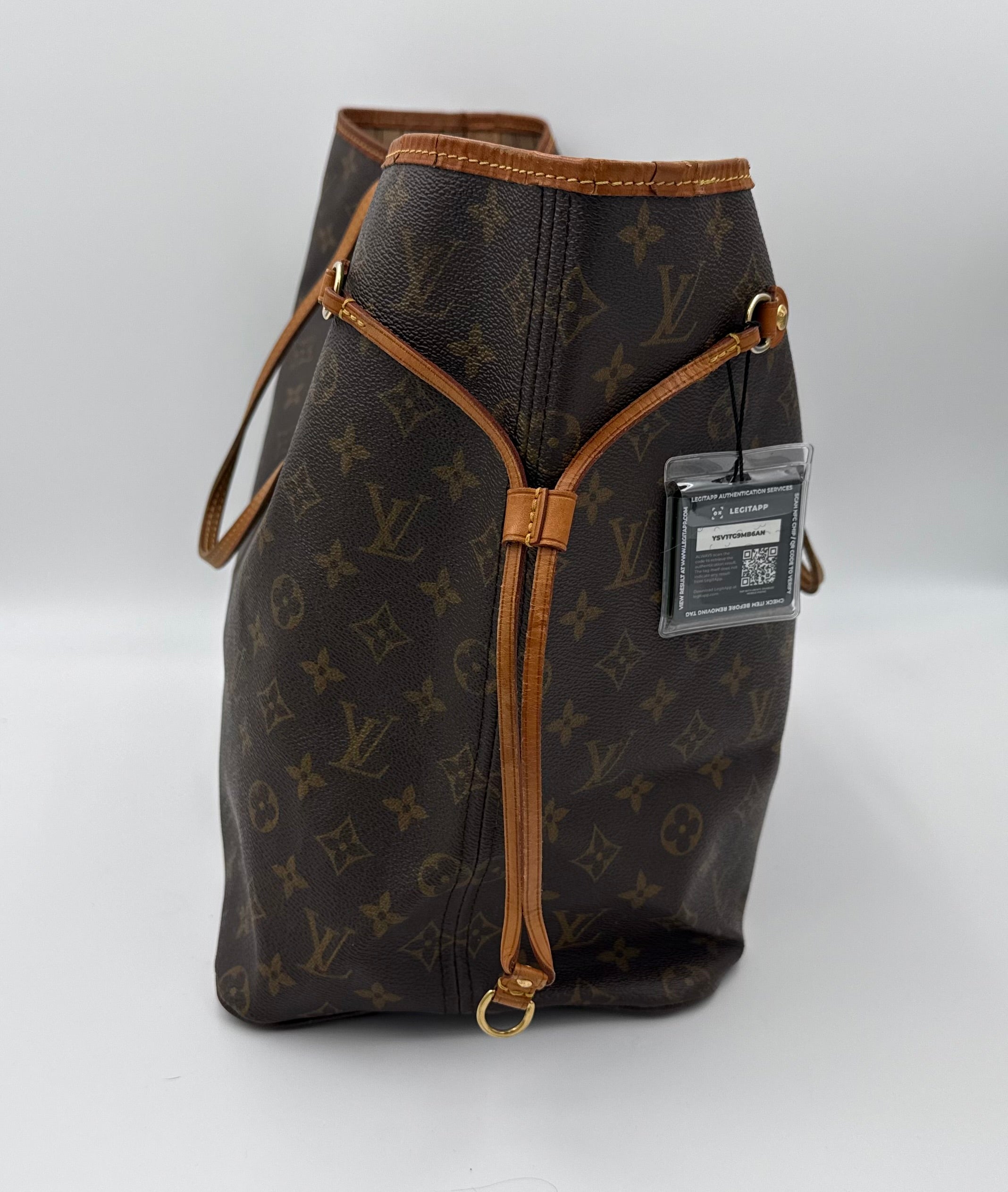 Designer handbag with monogram pattern and brown accents on a white background