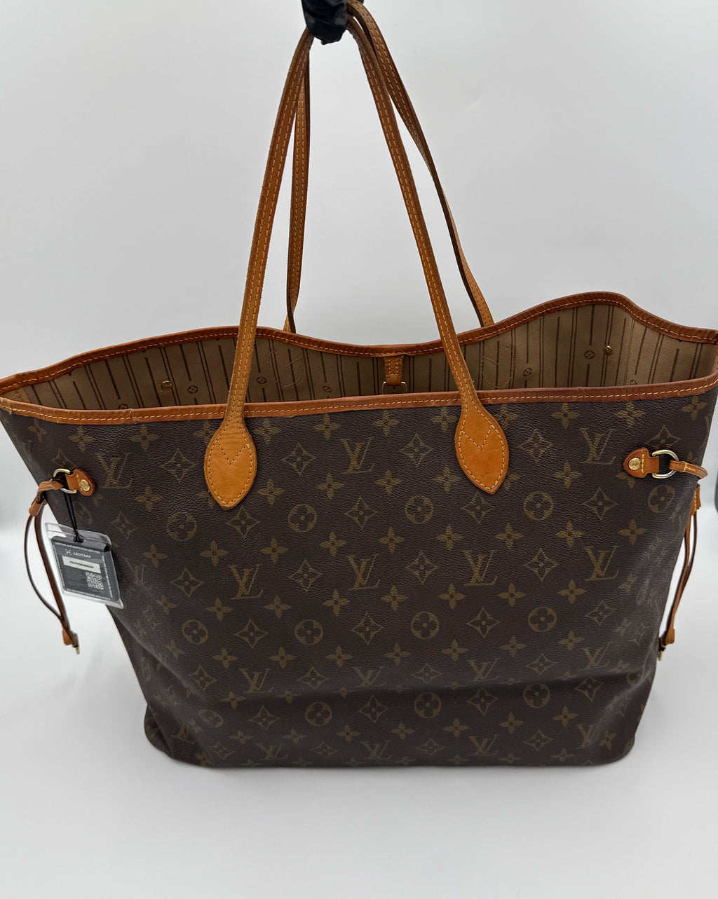 Brown monogram handbag with tan handles and accents on a white background