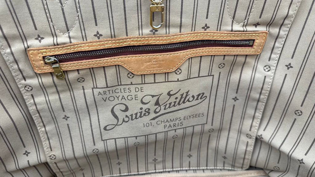 Louis Vuitton bag with visible brand logo and text on a striped fabric background