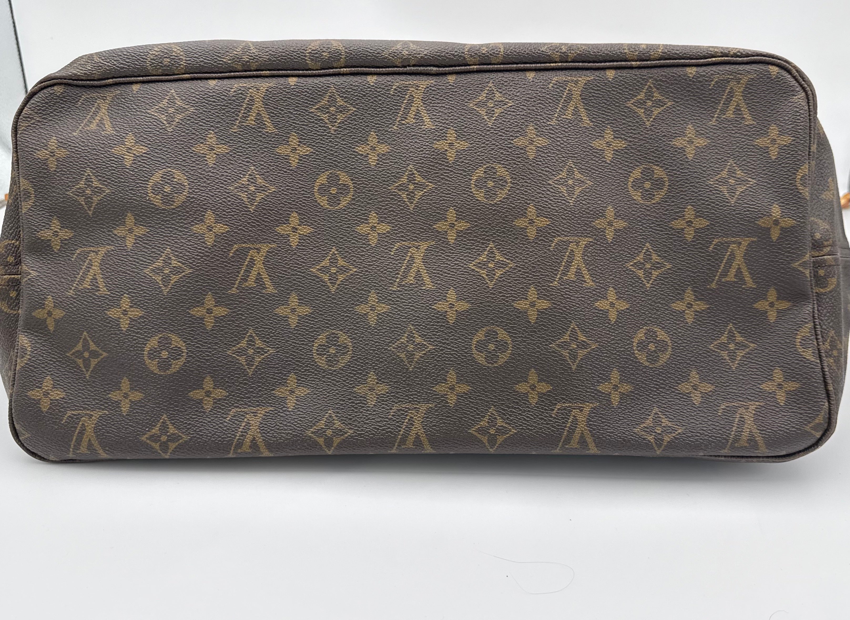 Brown leather bag with gold monogram pattern on a white background