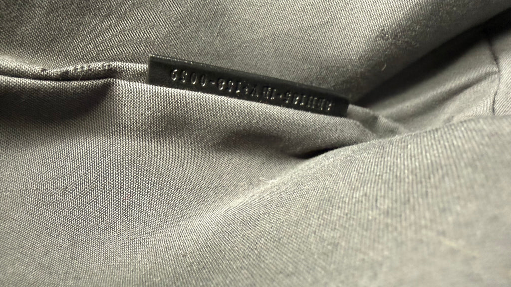 Close-up of a black fabric with a serial number tag on it.