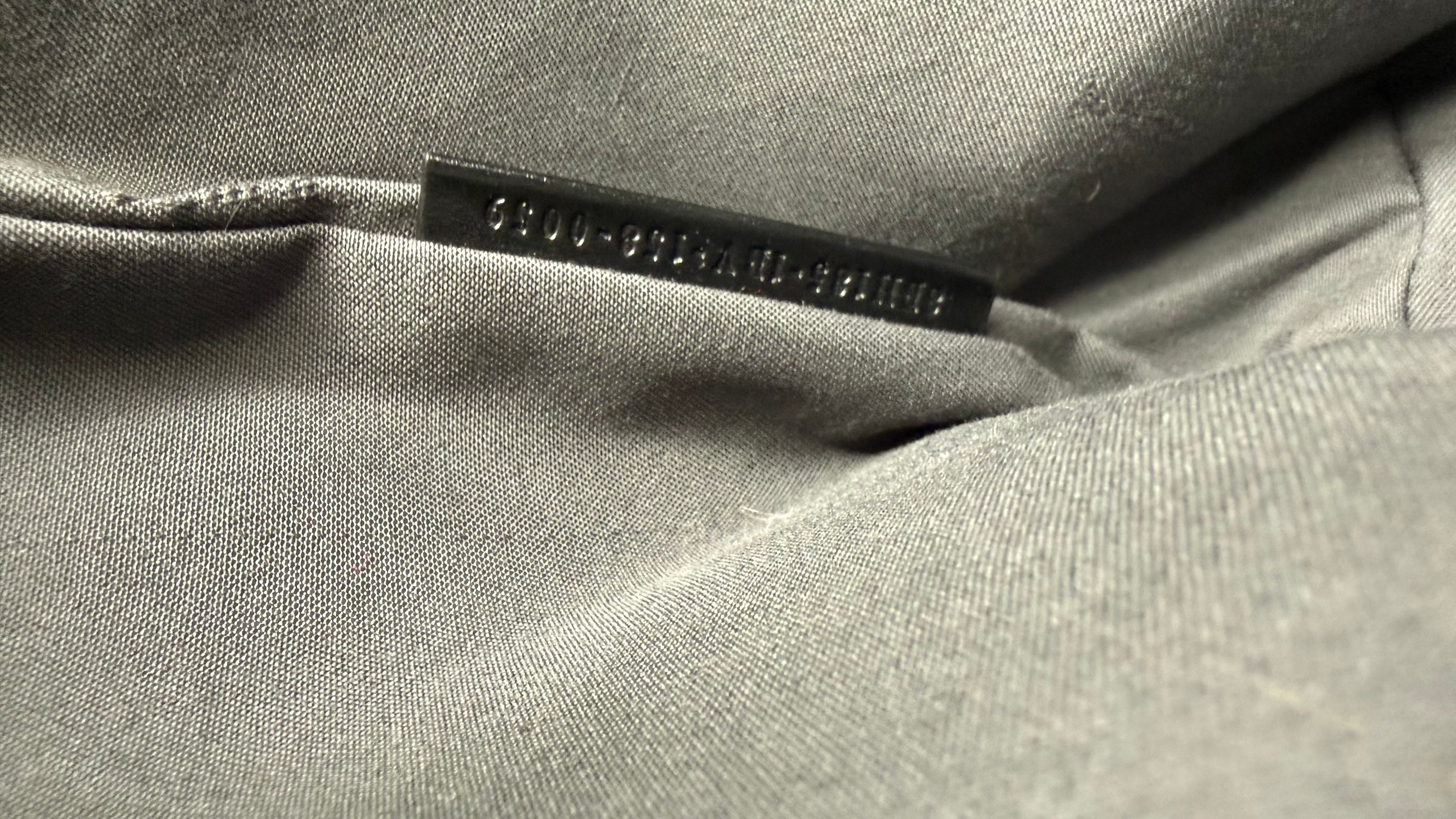 Close-up of a black fabric with a serial number tag on it.
