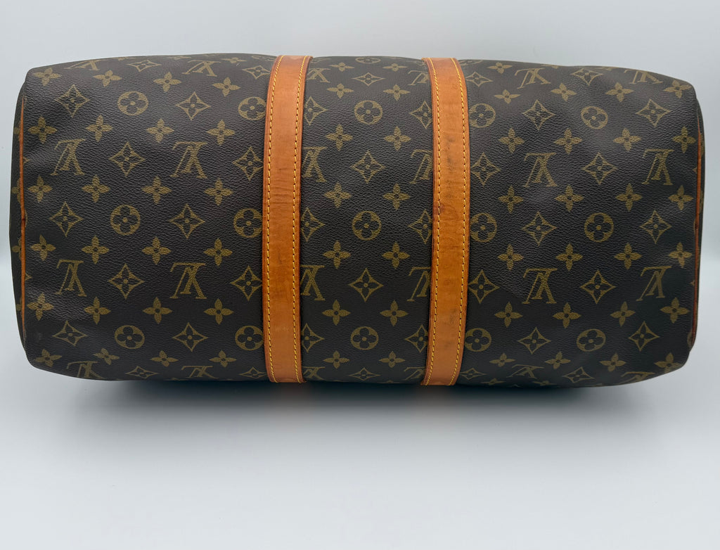 Designer duffel bag with monogram pattern on a white background