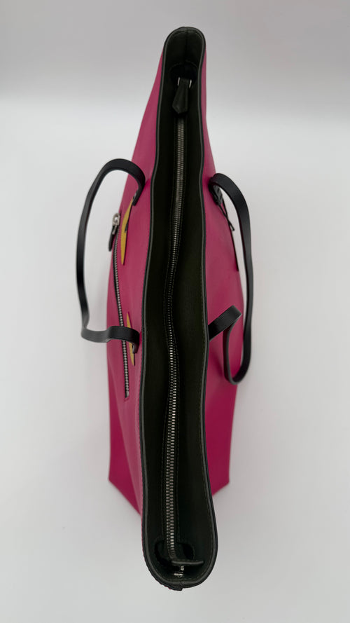 Pink handbag with black handles and zipper on a white background