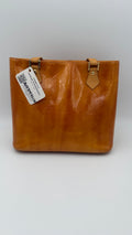 Louis Vuitton Vernis Houston tote in amber caramel patent leather with embossed monogram and shoulder straps on white background